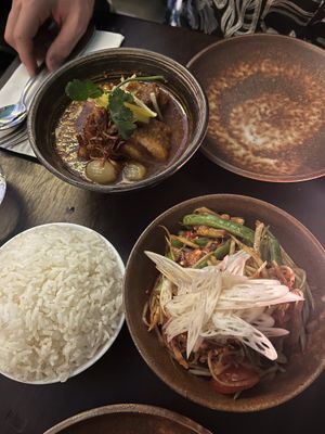Vegan pork belly in top left corner and som tam (green papaya) salad in bottom right  at Kruk in London
