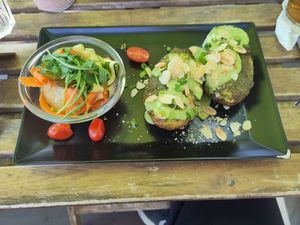 Cudaki - potatoes stuffed with tofu, vegan cheese, nutritional yeast, and cashew white cheese, baked with tempeh and served with spinach sauce, almonds chives, and a marinated zucc at Vege Miasto in Warsaw