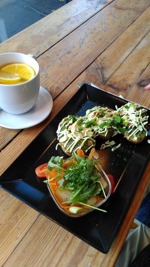 Veganised Polish dish with stuffed potatoes, served with pickles, and lemon tea at Vege Miasto in Warsaw