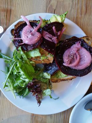 Smashed avocado tartine: Avocado, olive oil, black pepper, fleur de sel, toasted five-seed bread, pickled onions, coffee-roasted beets. at The Rose Establishment in Salt Lake City