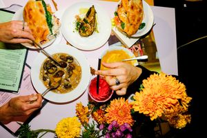 An average lunch table of 3 persons with the vegan dish of the week, a veggie side, a vegetarian and a vegan sandwich with their soup at Café Le Fontainas in Brussels