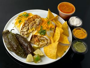 large Mission-style burrito w/green chicken + red sauce on the side + fried jalapeños (plated at home) at El Chupacabra - West in Seattle