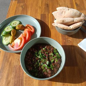 Ful medamas - stewed fava beans, pita, veggies. Cozy and nourishing :) at 1947 in Boronia