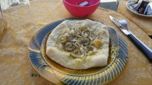 Small pizza without tomato but with onions and herbs. This is very small, so take it only if you are not that much hungry. at Ben D'Iddio in Pisa