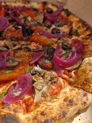 Neapolitan pizza with mushrooms, bell peppers, sweet onion, fresh olives and tomatoes and vegan cheese. Drizzled with garlic oil and sprinkled with parsley at Semo. Italian Street Kitchen  in Copenhagen