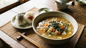 Enjoy a comforting plant-based meal featuring local Japanese regional dishes, including handmade rice balls and hearty vegetable soup. at BASAMA's Kitchen in Tsuruta