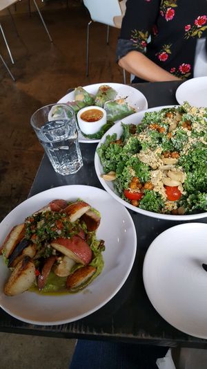 Fingerling potatoes over guacamole, Caesar salad with crunchy chickpeas, and kimchi spring rolls. at Avo in Nashville