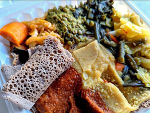 Feast for one! Not pictured are the diced tomatoes with onion, packaged separately, and lentil samosa appetizer. I will be craving this injera bread! at Rahel's Vegan Cuisine in Los Angeles