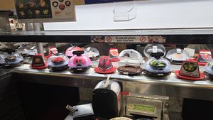 Revolving sushi display (watermelon, edamame, cucumber, etc.) at Kura Revolving Sushi Bar in Glendale