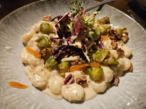 Gnocchi in creamy sauerkraut, oven-baked Brussels sprouts, apricots & smoked beans at Die FETTE BEETE in Krefeld