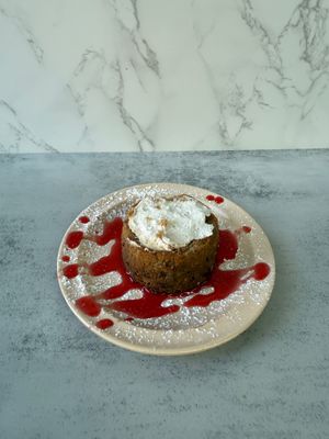 This moist, buttery cake is filled with fresh banana and topped with a luxurious layer of cream cheese frosting. at Aisha's Plant-Based Eatery in Miami