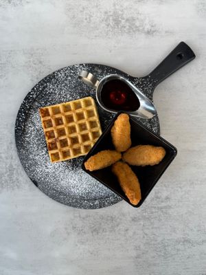 Crispy, golden plant-based chick'n served over a fluffy french vanilla waffle, drizzled with maple syrup and a touch of vegan butter for the perfect sweet-and- savory classic. at Aisha's Plant-Based Eatery in Miami