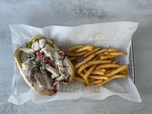 Chick’n Philly - hoagie roll loaded with savory, marinated plant-based chick'n. Topped with vegan provolone cheese and mixed with tender caramelized onions & bell peppers at Aisha's Plant-Based Eatery in Miami