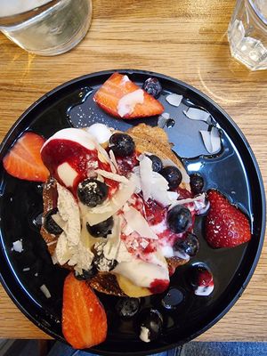 Pancake with coconut yoghurt, berries, banana and compote at Kin Cafe Vegetarian in London