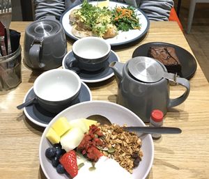 Coconut youghurt with fruit and granola on front. Scrambled eggs and (not vegan) brownie in the back. Nice flavourful teas!  at Kin Cafe Vegetarian in London