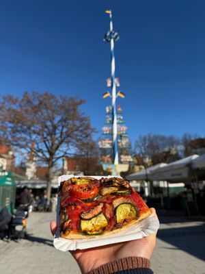 enjoying a piece of organic veggie pizza under the warm winter sun at Munich Vegan Tours in Munich