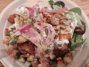 Custom bowl: Greens, Brown Rice, Hummus, Eggplant Dip, Falafel, white Sweet Potatoes, FireRoasted Corn, Broccoli, Tomato + Cucumber, Pickled Onions, pita strips and garlic dressing at CAVA in Naples