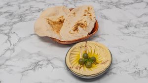 Authentic Syrian hummus served with freshly baked Arabic bread, a creamy and vegan-friendly Middle Eastern favourite. at Damastique in York
