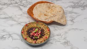 Smoky roasted aubergine blended with tahini and spices, served with warm Arabic bread. A classic Syrian vegan dip. at Damastique in York