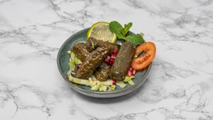 Hand-rolled vine leaves stuffed with seasoned rice, herbs and spices. A classic Syrian vegan appetiser bursting with flavour. at Damastique in York