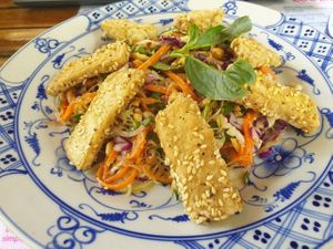 Tofu Nyoam (vegan) - Traditional cambodian salad of plant roots, cabbage and carrot tossed with herbs and peanuts, in a light chilli coconut dressing topped with sesame tofu. at Epic Arts Cafe in Kampot