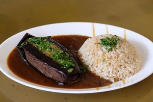 Moussaka: Baked eggplant pockets stuffed with a tofu & green lentils patty with flavorful tomato sauce, served with whole rice/buckwheat & date sauce at Nagila in Jerusalem