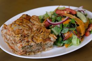 Lasagna: Layers of cashew cheese, pesto, spinach, roasted mushrooms and homemade tomato sauce, served with a fresh side salad at Nagila in Jerusalem