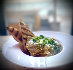 Jerusalem artichoke, garlic and black truffle ravioli, swimming in a dairy-free white wine and chive beurre blanc with griddle toasted sourdough.   at Cafe Needles Eye in Newbiggin-by-the-sea