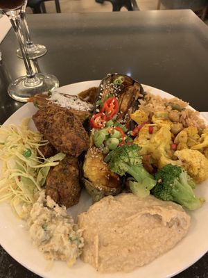 Main plate- miso and maple glazed aubergine, veg fried rice, roasted cauliflower with pomegranate, roasted broccoli, coconut fritters, vegan slaw, baba ganoush, hummus.  at Ethos in London
