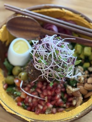 Mediterranean falafel bowl. Hummus, olives,  tomatoes with greens. I liked pomegranate and the dressing was pretty nice too.    at Roots Plant-based Cafe - Hẻm 41 Xuan Thuy in Ho Chi Minh City
