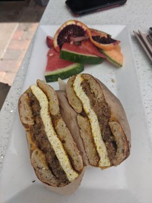 Bagel sandwich with tofu, sausage, and american cheese. Comes with fruit. 😋 at JOi Café in Westlake Village