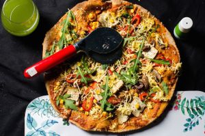 Vegan eggplant-zuchinni pizza. With vegan cheese, ruccola and sprinkled with basil at Rawmazing in Bucharest