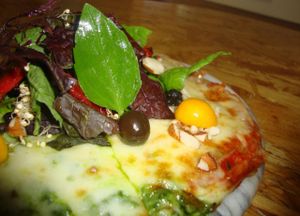 Delicious artisanal pizza, half pesto and half pomodoro, with a mixed of greens, goldenberries and mucho more :) Vegan option available.  at Vegetarian by Franco in Lima