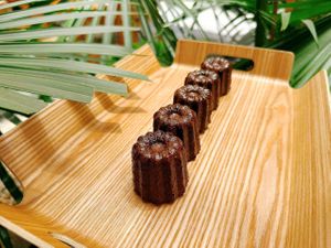 Traditional French canelé with a caramelized crust and soft, custardy center. at La Miette Bakery & Bistro in Ninh Binh