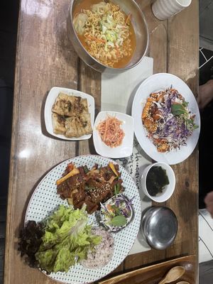 This is 3 separate entrees, their names escape me besides the Ramen with dumplings but the other two are the rice chicken on the right and fried chicken in the middle   at Dajeon Cafe in Busan