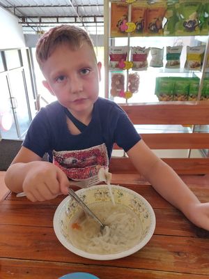 My six year old son with soup at Porwin Vegetarian in Chiang Rai