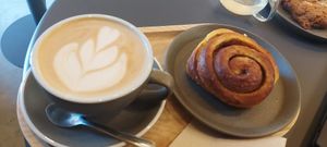 Oat latte and a cinnamon bun at Olmo Coffee&Co in Mem Martins