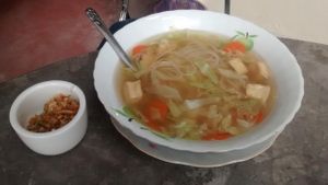 noodle soup with tofu and a portion of roasted garlic at Same Same Restaurant and Guesthouse in Luang Prabang