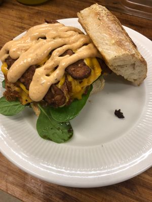 This is the brunch burger... just egg, tempeh bacon, violife cheddar and sun dried tomato aioli top their house made black bean and quinoa burger on a bed of spinach on sourdough!! at The Farm Concessions and Café in Keene