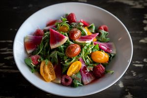 Arugula, cherry tomatoes, raspberry, radish, raspberry dressing. (GF)  at The Wayward Vegan in Seattle