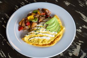 Sunshine Omelet  (GF)
Tempeh bacon, diced onion, diced tomatoes, cheddar cheese sauce, topped with avocado, and ranch dressing. Served with home fries. (GF)  at The Wayward Vegan in Seattle