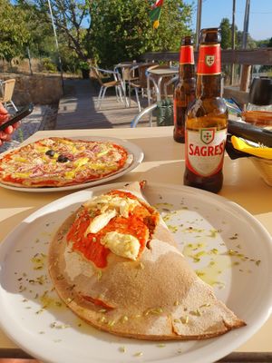 Vegan Calzone with almond cheese, non-vegan tuna pizza in the background  at Trigo Vermelho in Aljezur