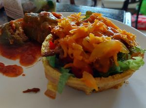 Belgium bowl with romania lettuce top up with bbq soy curls and carrot and onio pickles. Stuffed Jalapeño and salsa sauce. at Homey Food & Cafe in Calgary