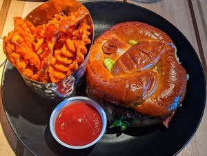 Veggie burger with pretzel bun and sweet potato fries at DEN - Root Down - TC in Denver