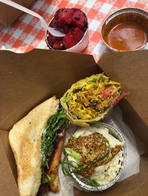 Tempeh sandwich, jackfruit wrap, potato salad, watermelon salad. at Dharma Southern Chick'n in Orlando