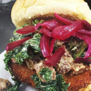 Fried green tomato sandwich w/ garlicky kale + vegan sausage + pickled beet greens  at Dharma Southern Chick'n in Orlando