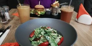 A smoothie, fresh juice, Caesar salad with vbacon and a cheezeburger at Green Pumpkin in Riga