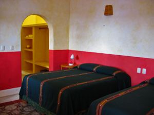 This spacious simply decorated air-conditioned room has two queen beds, private bathroom with shower, a ceiling fan, a separate dressing area and an uncluttered Mexican decor. at Hotel MedioMundo in Merida