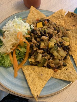 Protein (maybe soy, idk) with beans, squash, zucchini, peppers and delicious spices. Served with chips and a fresh salad for menu del día at Veg Station in Medellin