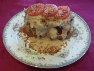 Open faced Millet 'Meatloaf' Sandwich smother in smashed potatoes and gravy, and topped with fresh tomatoes and 'bacon' at Fortuitea Cafe and Bakery in Washington